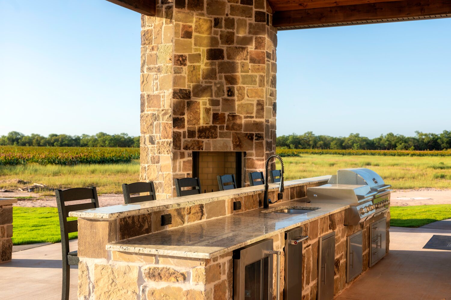 Outdoor kitchen and stone fireplace at Pecan Creek Lodge